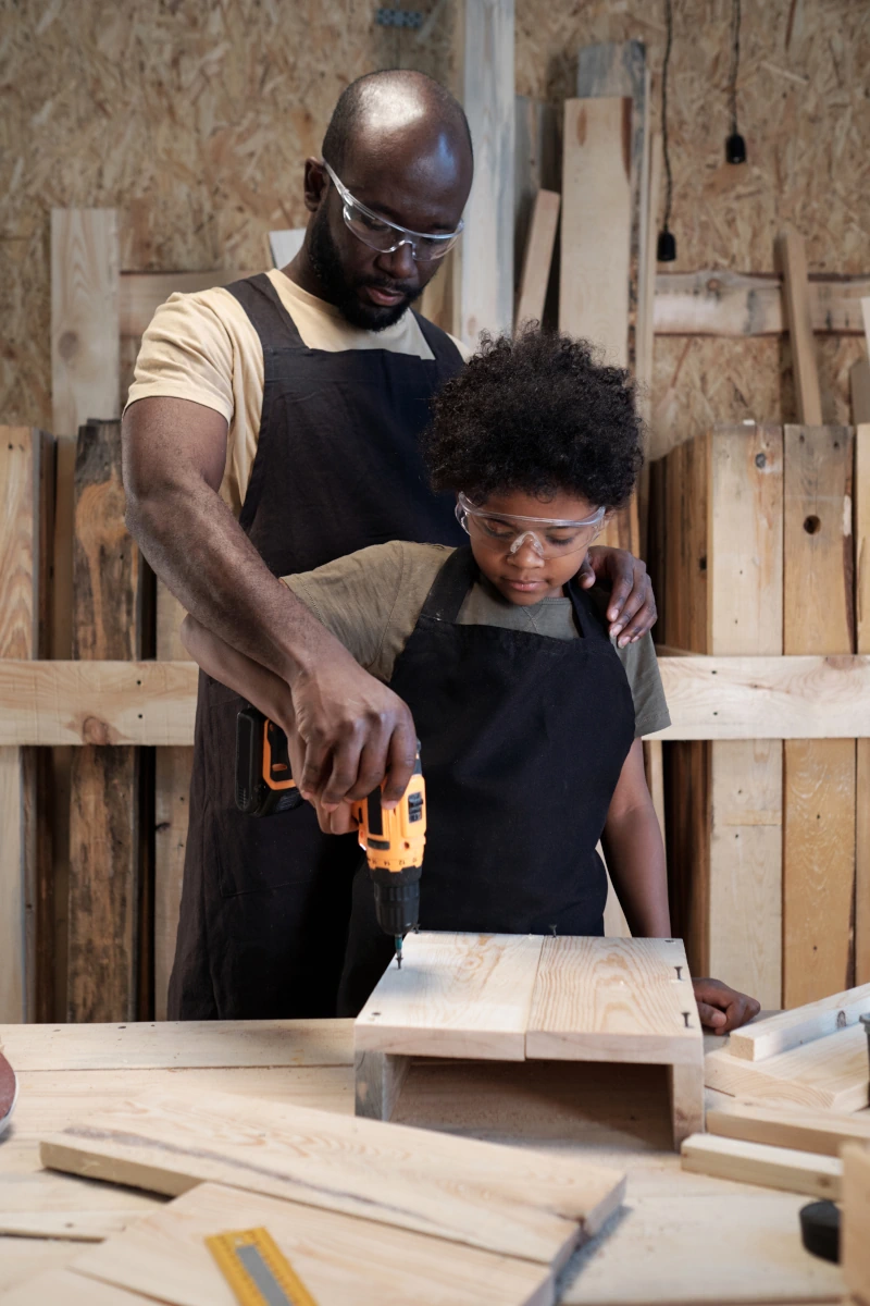 father-teaching-son-carpentry-2025-03-14-10-29-24-utc Father Teaching Son Carpentry. Son learning the family business.